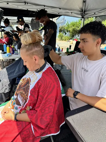 Volunteer providing a free haircut at a Soul Saving Productions community event