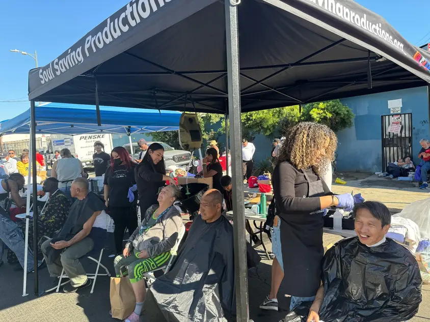 Volunteer giving a free haircut at a Soul Kutz community event
